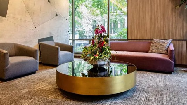 Inviting resident lounge with modern seating, a stylish coffee table, and large windows at Elm Street Plaza Chicago