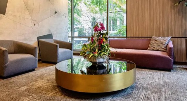 Inviting resident lounge with modern seating, a stylish coffee table, and large windows at Elm Street Plaza Chicago