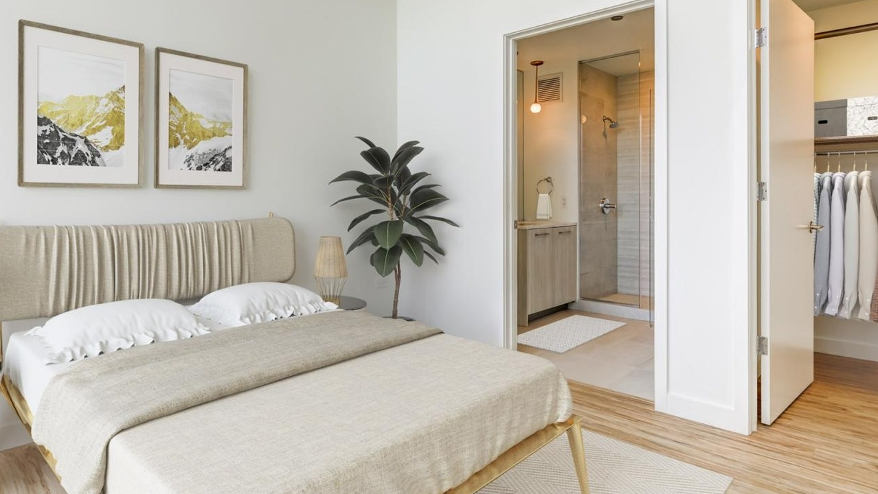 A modern bedroom with a comfortable bed, stylish decor, and an en-suite bathroom visible through an open doorway at EMME Chicago in Chicago