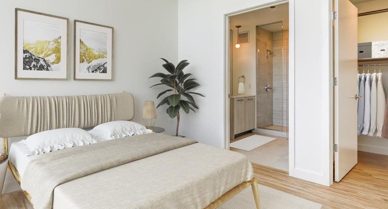 A modern bedroom with a comfortable bed, stylish decor, and an en-suite bathroom visible through an open doorway at EMME Chicago in Chicago