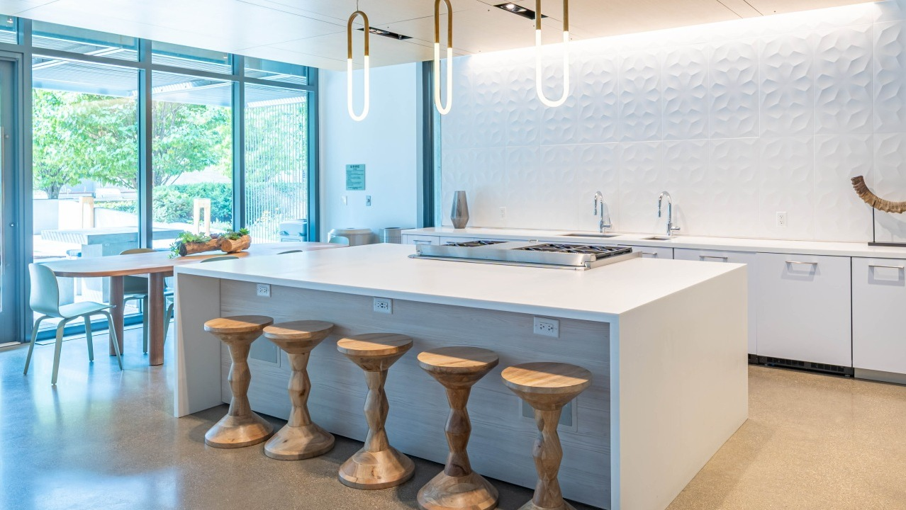 Spacious communal chef's kitchen with a large island, bar seating, and modern appliances for resident use at EMME Chicago in Chicago
