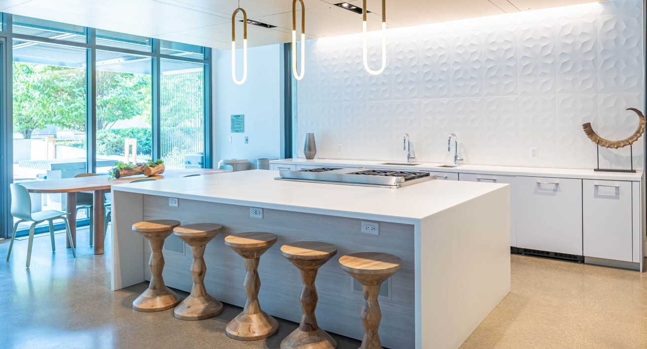 Spacious communal chef's kitchen with a large island, bar seating, and modern appliances for resident use at EMME Chicago in Chicago
