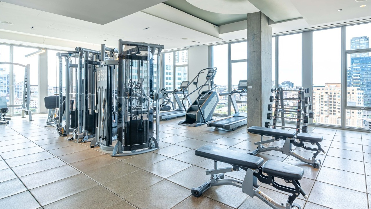 Fully equipped fitness center with a variety of strength training and cardio machines, offering city views at EMME Chicago in Chicago