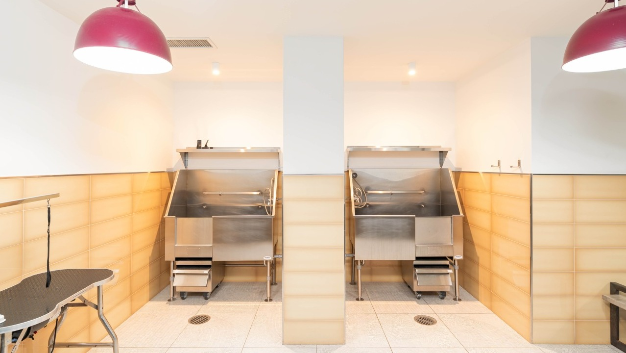Dedicated pet spa and grooming station with two stainless steel tubs and a drying table at EMME Chicago in Chicago