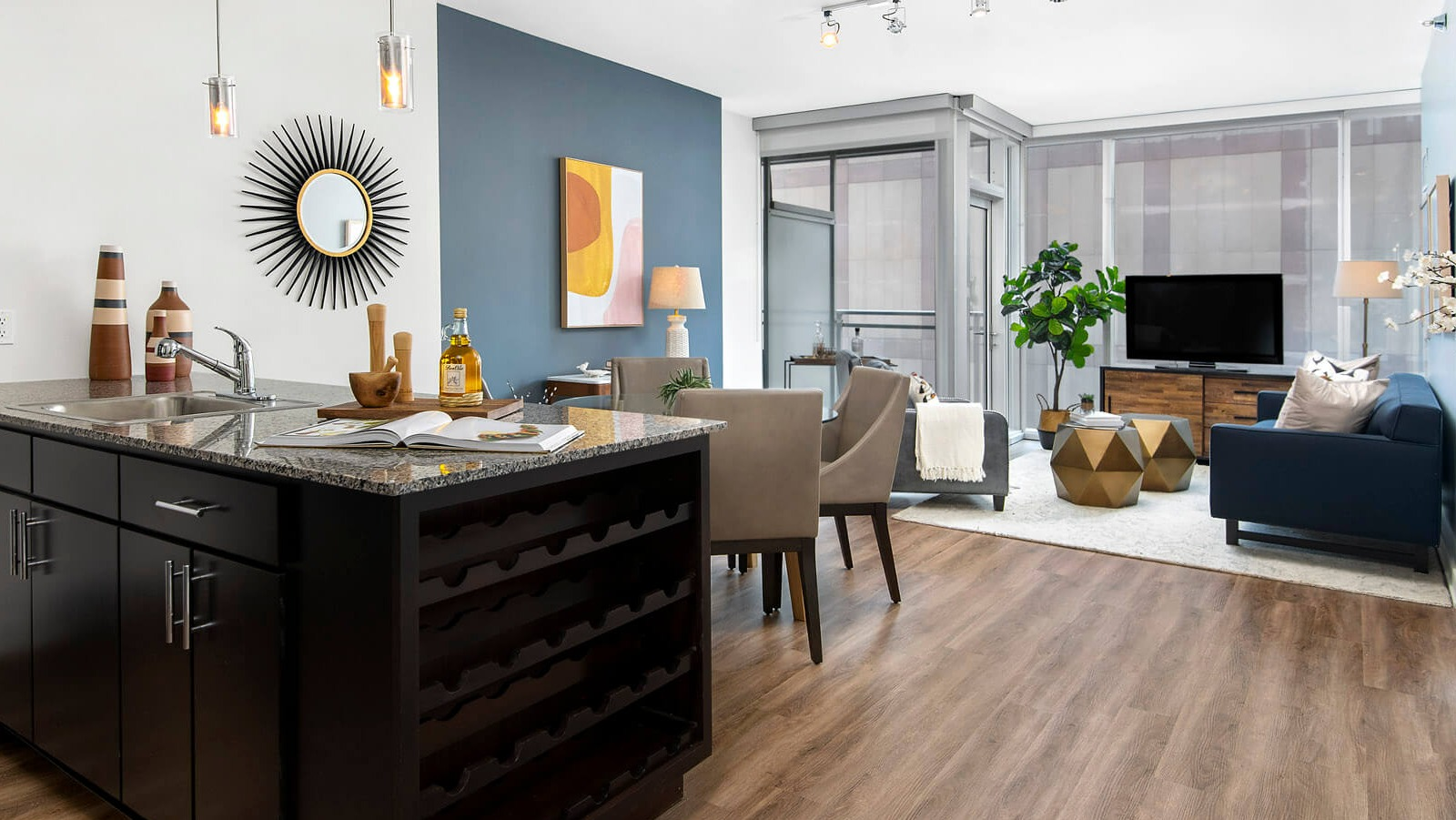 Env Chicago open-concept living and kitchen area featuring a stylish blue accent wall and modern furnishings