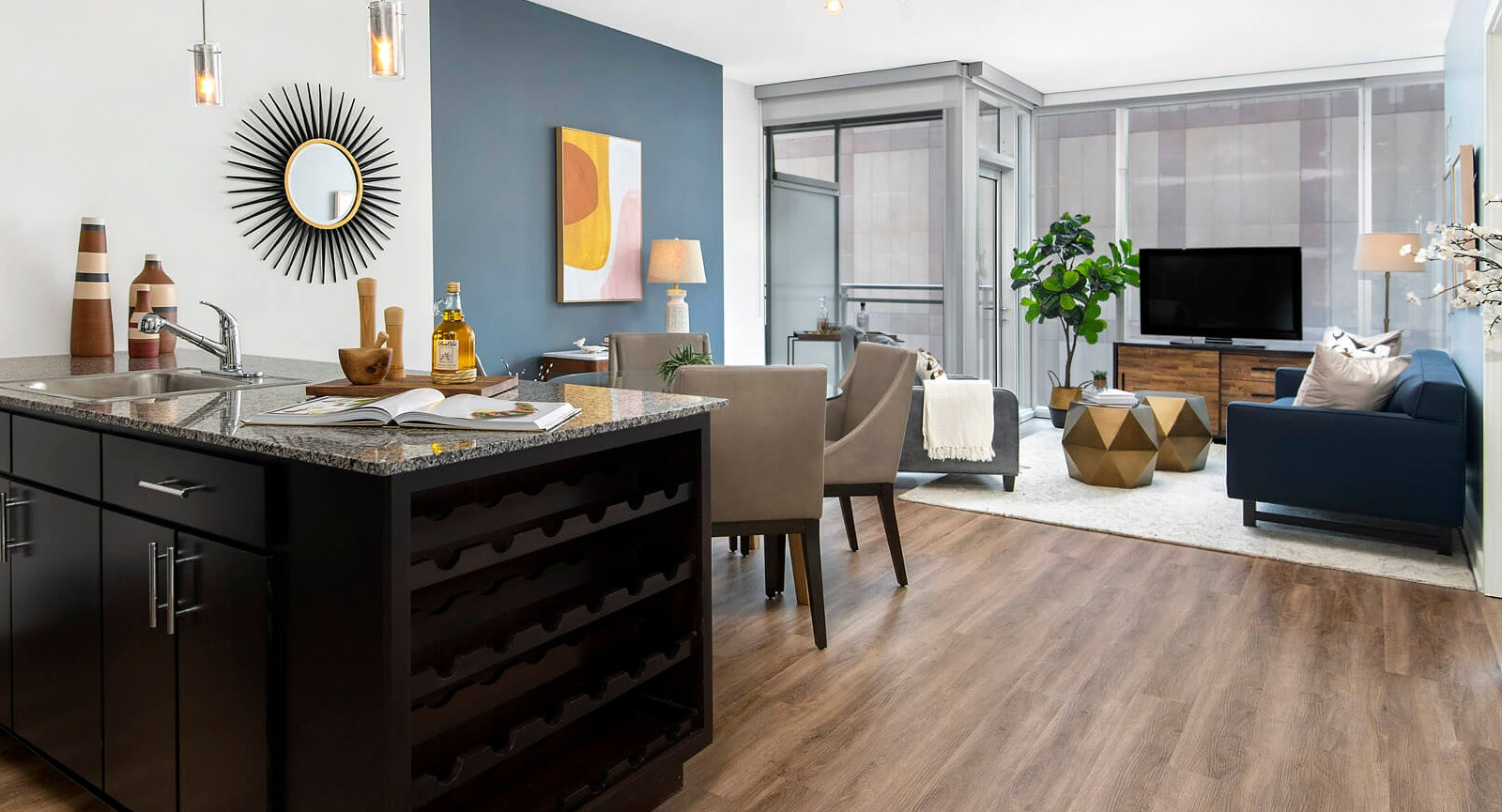 Env Chicago open-concept living and kitchen area featuring a stylish blue accent wall and modern furnishings