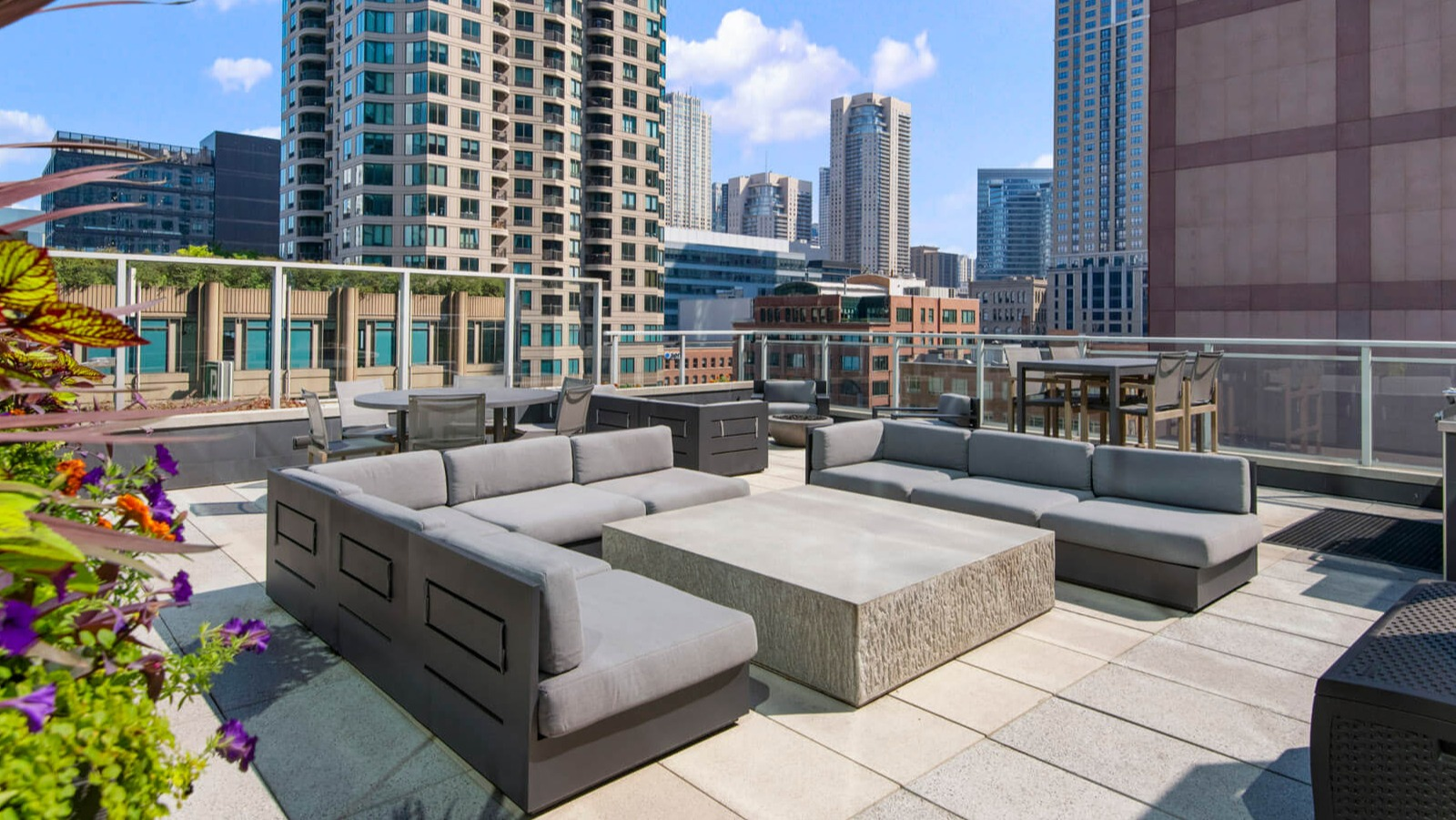 Env Chicago rooftop patio on a sunny day, featuring modern outdoor furniture and urban high-rise views