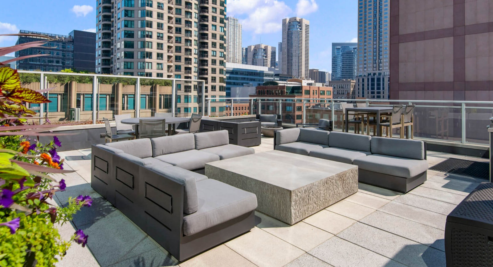 Env Chicago rooftop patio on a sunny day, featuring modern outdoor furniture and urban high-rise views