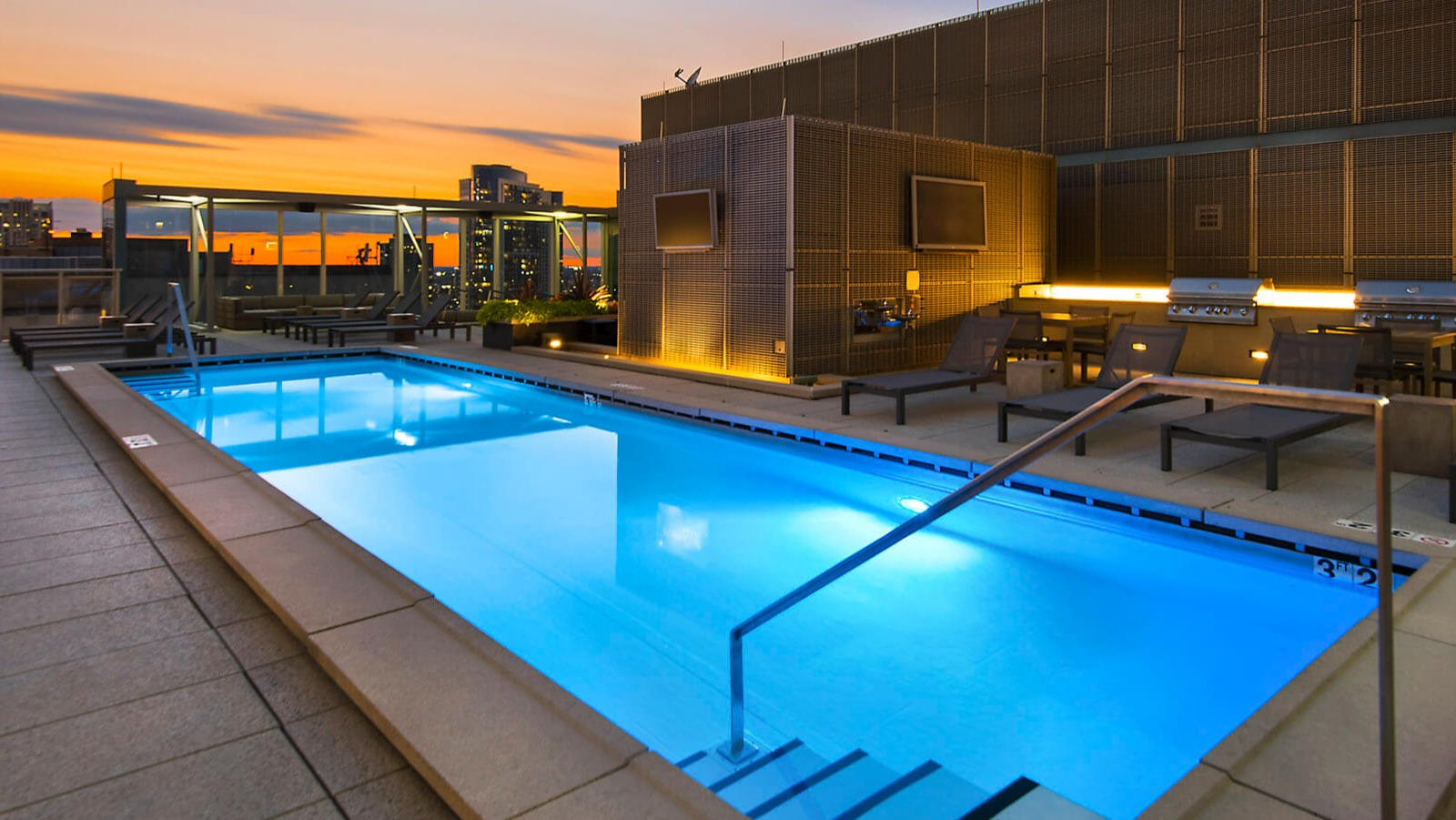 Env Chicago rooftop pool at sunset, offering stunning city views and a vibrant sky, perfect for relaxation