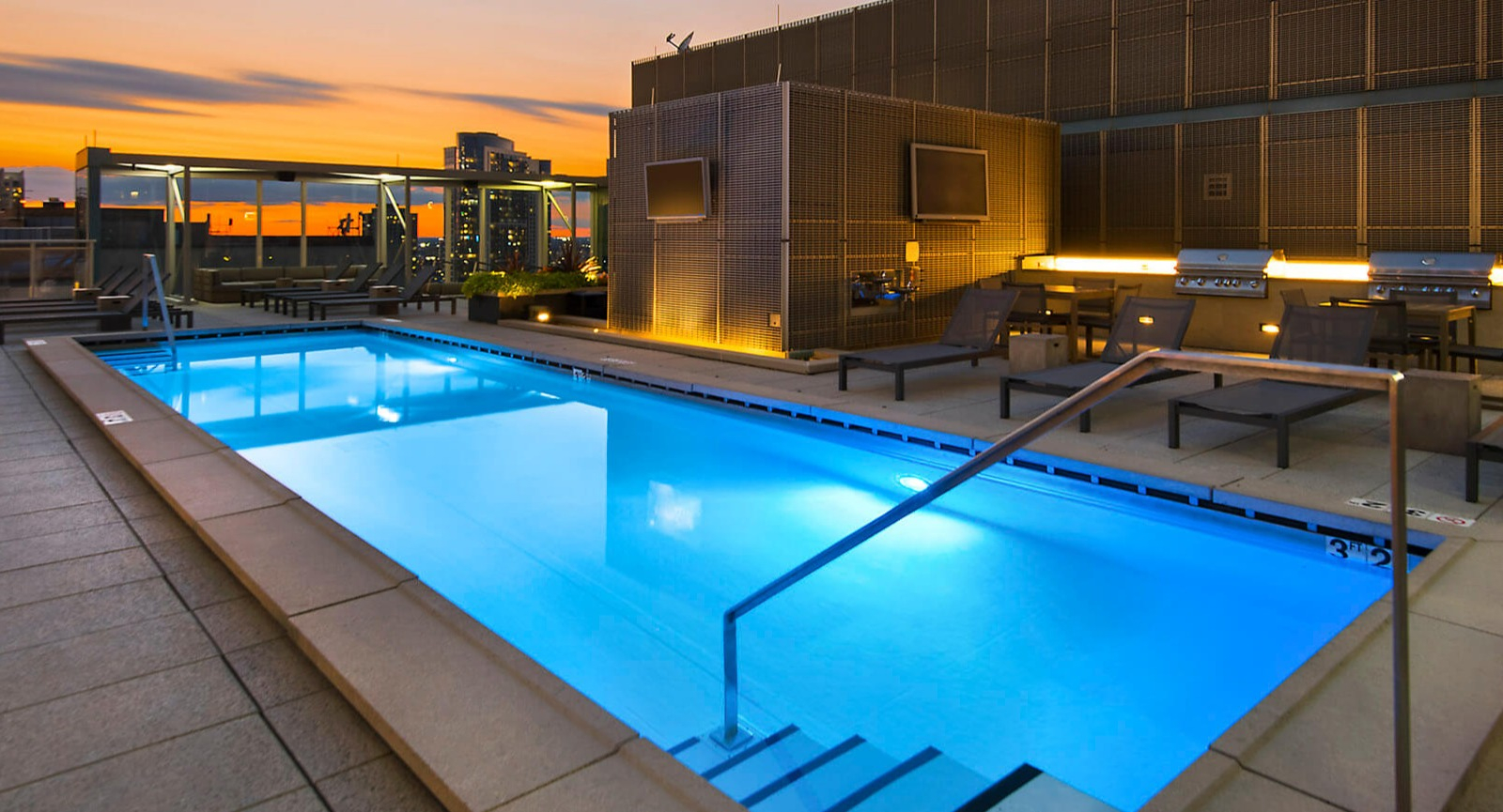 Env Chicago rooftop pool at sunset, offering stunning city views and a vibrant sky, perfect for relaxation
