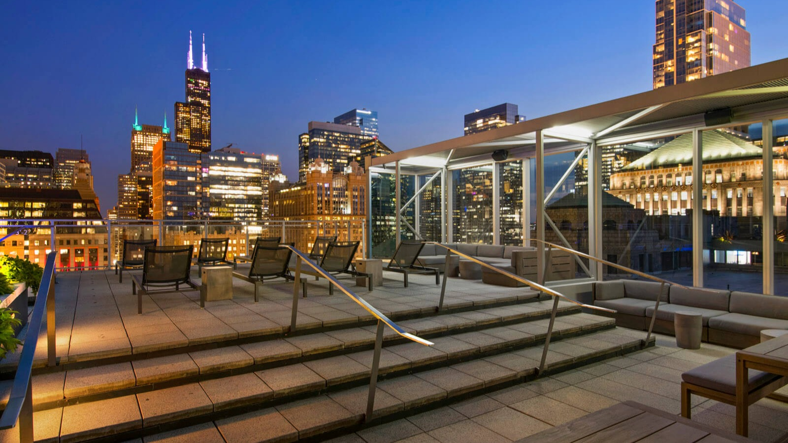 Env Chicago rooftop terrace featuring stylish outdoor seating and an expansive cityscape at twilight