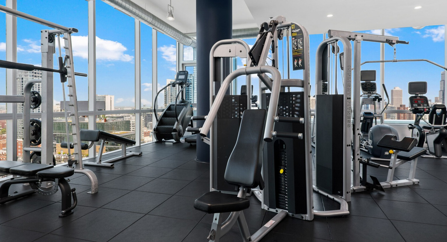 Env Chicago weight room featuring extensive strength training equipment and bright, natural light from large windows