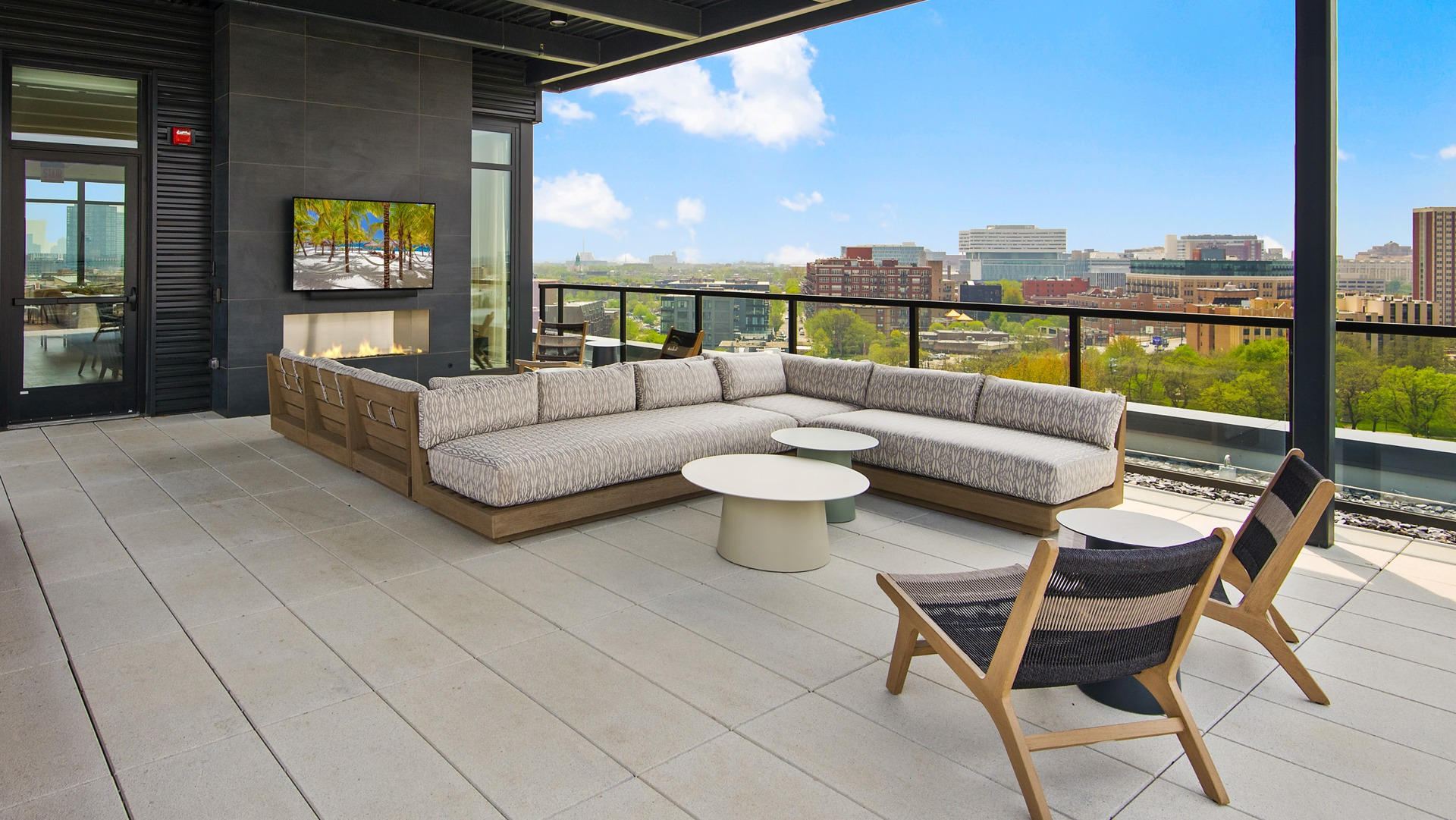 Covered outdoor lounge area on the rooftop at Evo Union Park in Chicago, with a large sectional sofa, fireplace, and flat-screen TV