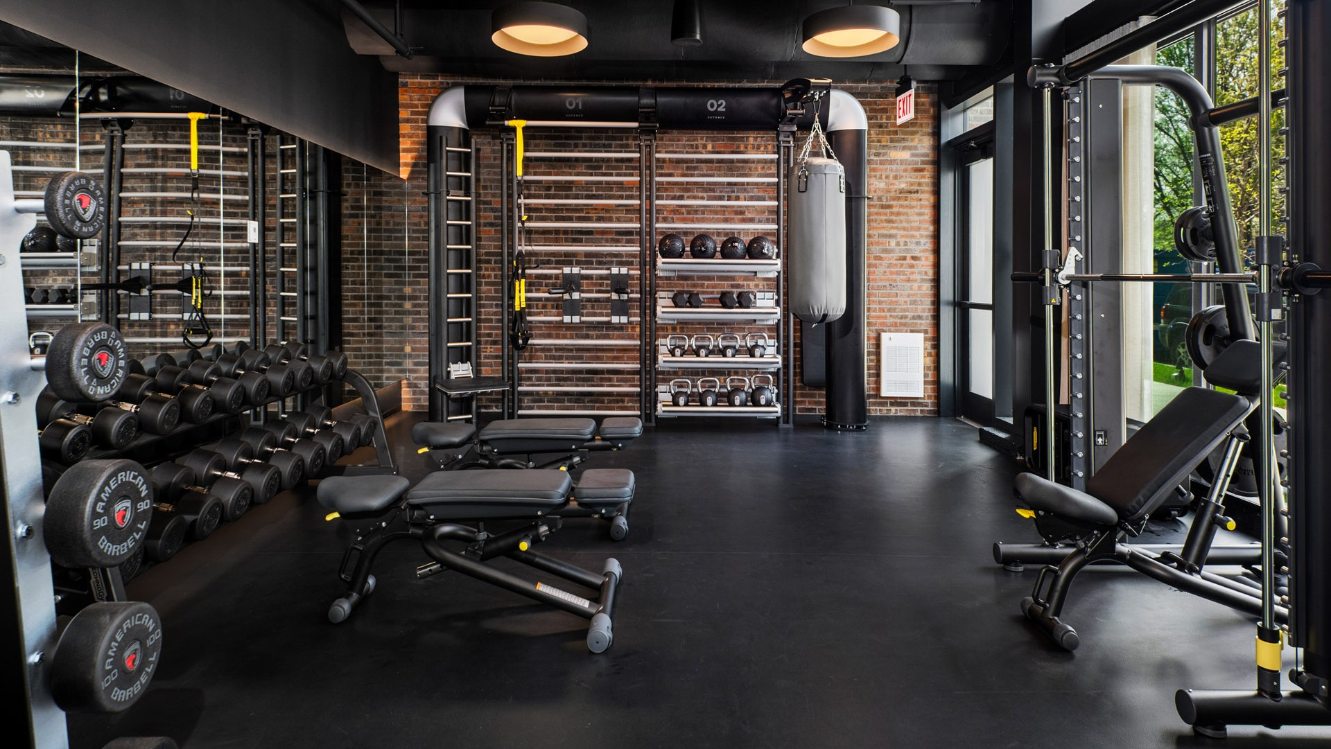 Dedicated free weight and strength training area at Evo Union Park's gym in Chicago, featuring dumbbells, benches, and a punching bag