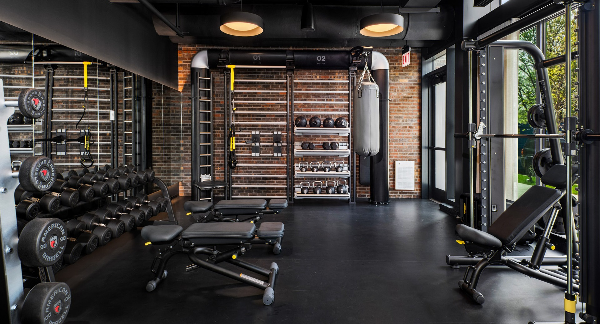 Dedicated free weight and strength training area at Evo Union Park's gym in Chicago, featuring dumbbells, benches, and a punching bag