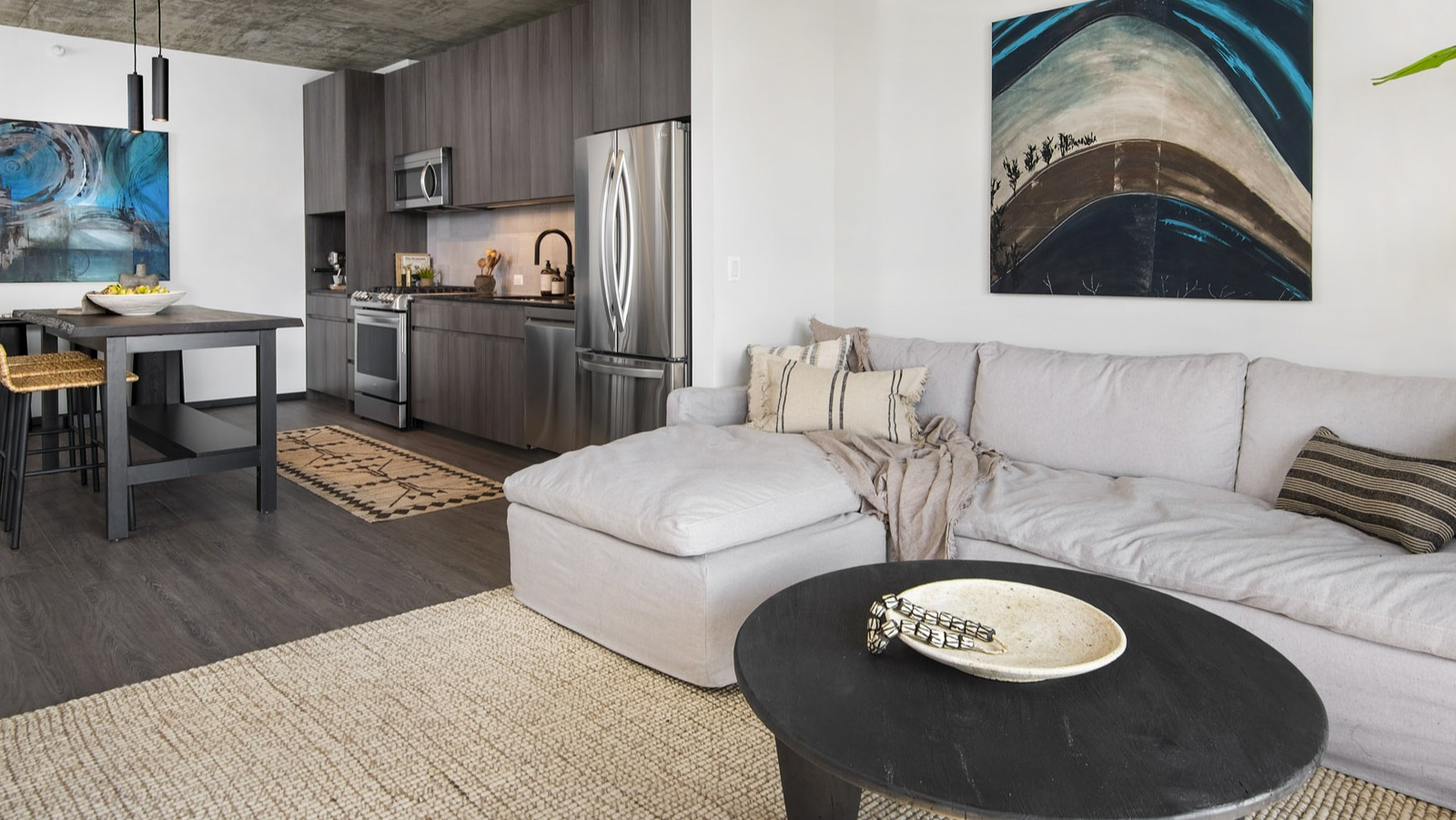 Wide view of an apartment at Evo Union Park in Chicago, highlighting the open connection between the cozy living room and the sleek kitchen