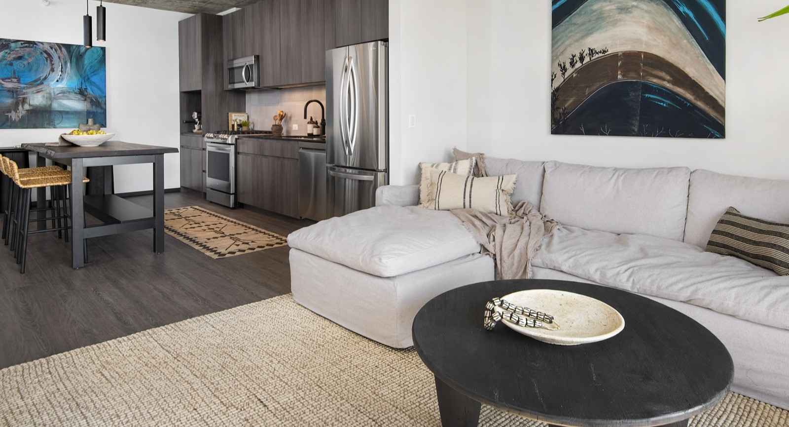Wide view of an apartment at Evo Union Park in Chicago, highlighting the open connection between the cozy living room and the sleek kitchen