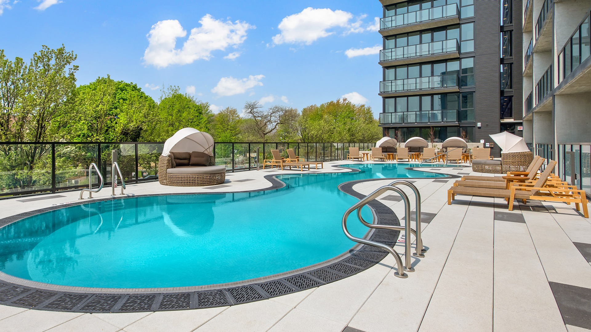 Serene outdoor swimming pool at Evo Union Park in Chicago, with inviting lounge cabanas and ample space for relaxation under the sun