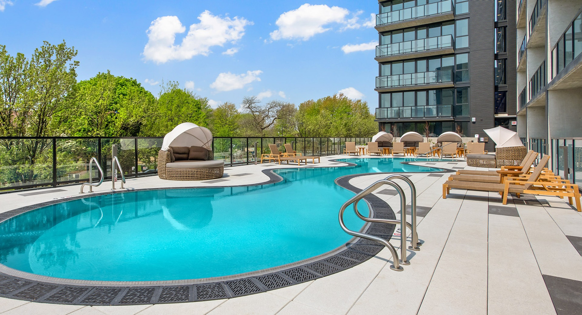 Serene outdoor swimming pool at Evo Union Park in Chicago, with inviting lounge cabanas and ample space for relaxation under the sun