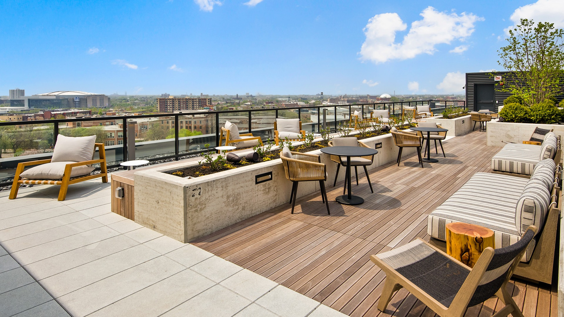 Relaxing rooftop lounge at Evo Union Park in Chicago, with comfortable outdoor seating, lush planters, and panoramic city skyline views