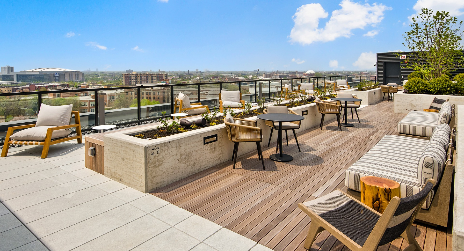 Relaxing rooftop lounge at Evo Union Park in Chicago, with comfortable outdoor seating, lush planters, and panoramic city skyline views