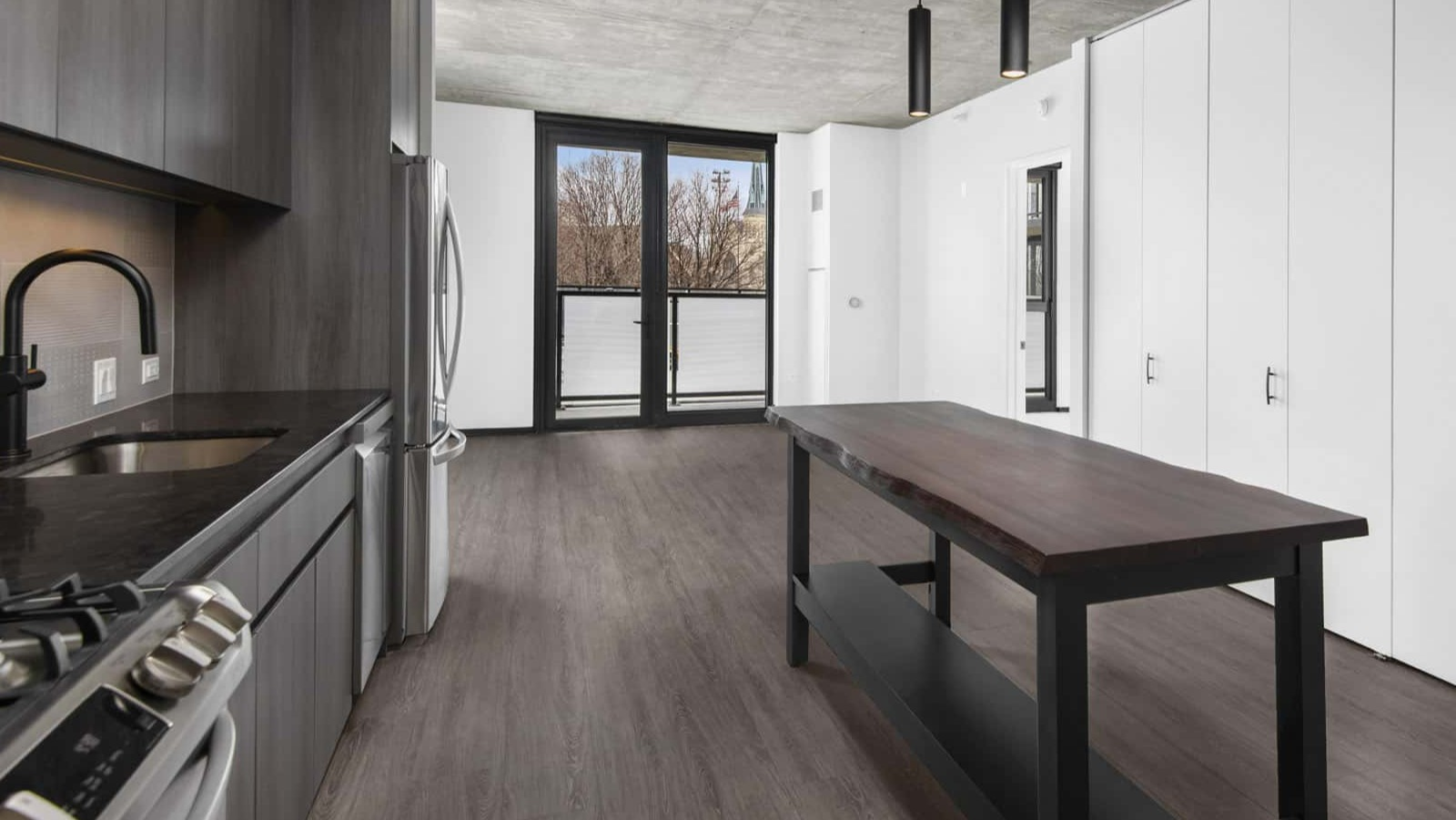 Bright studio apartment at Evo Union Park in Chicago, featuring a modern kitchen island, ample storage, and an open layout leading to a large window