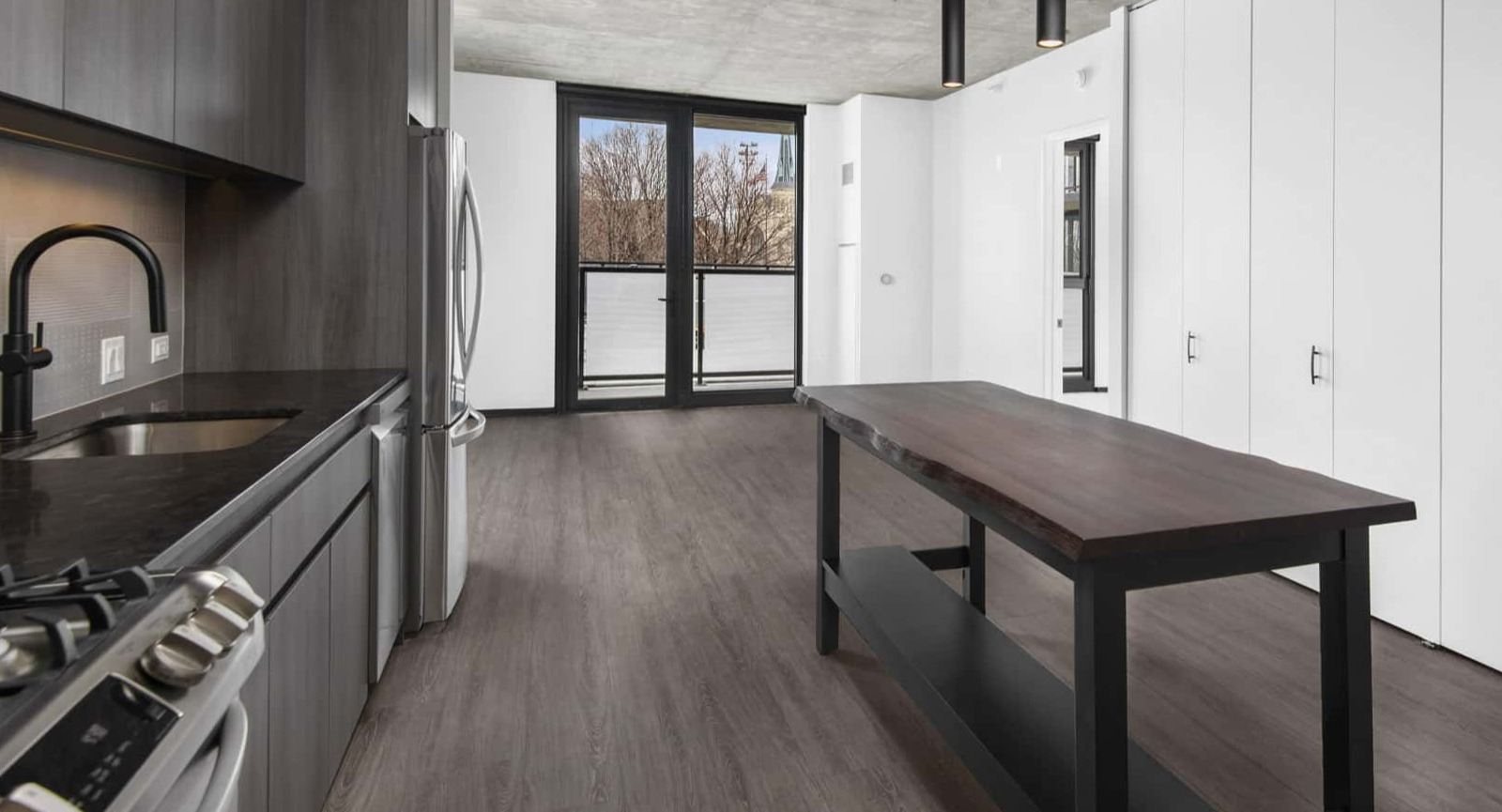 Bright studio apartment at Evo Union Park in Chicago, featuring a modern kitchen island, ample storage, and an open layout leading to a large window