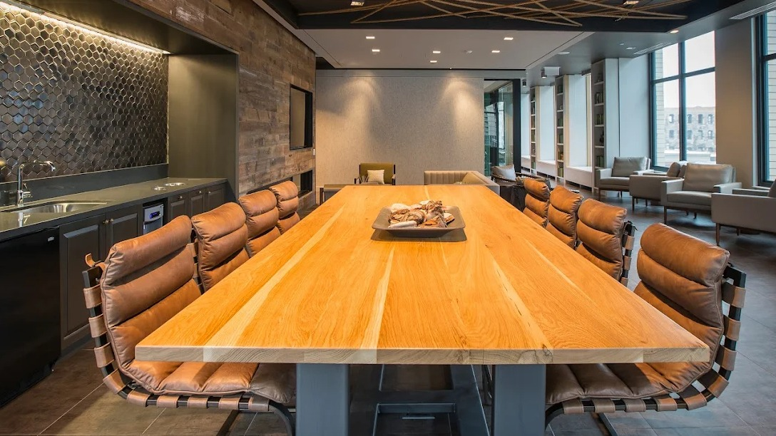 Elegant dining room with a long communal table, leather chairs, and a modern ceiling design, perfect for gatherings at Exhibit on Superior in Chicago