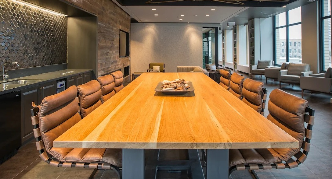 Elegant dining room with a long communal table, leather chairs, and a modern ceiling design, perfect for gatherings at Exhibit on Superior in Chicago