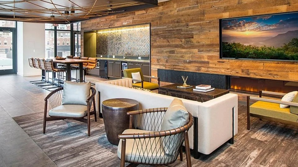 Stylish resident lounge with a cozy fireplace, kitchenette, various seating options, and city views at Exhibit on Superior in Chicago