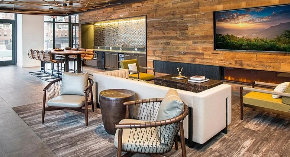 Stylish resident lounge with a cozy fireplace, kitchenette, various seating options, and city views at Exhibit on Superior in Chicago