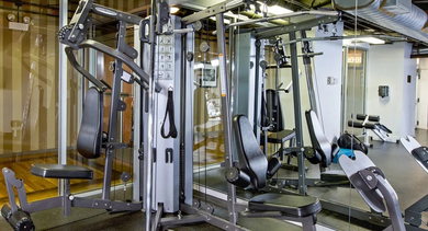 Well-equipped fitness center at Fisher Building Apartments in Chicago, offering a variety of machines for a full-body workout