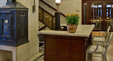 Historic reception area at Fisher Building Apartments in Chicago, showcasing original architectural details, a classic fireplace, and a welcoming ambiance