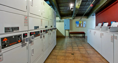 Convenient communal laundry room at Fisher Building Apartments in Chicago, equipped with multiple washing and drying machines