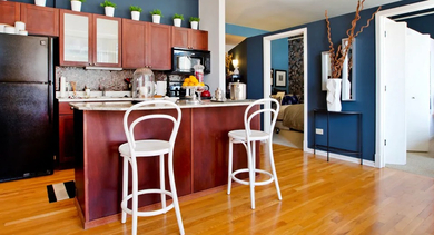 Open-concept apartment kitchen at Fisher Building Apartments in Chicago, showcasing a spacious island, modern appliances, and hardwood flooring