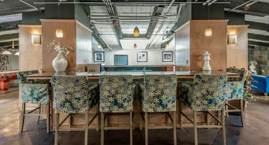 Vibrant resident lounge and bar area at Fisher Building Apartments in Chicago, with unique patterned chairs, a billiards table, and exposed ceilings