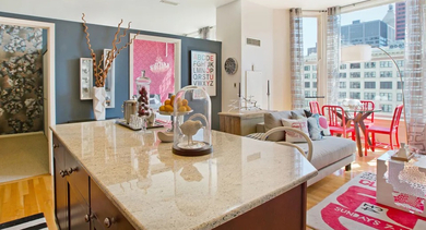 Spacious apartment living room and kitchen area at Fisher Building Apartments in Chicago, with large windows, bright decor, and a kitchen island