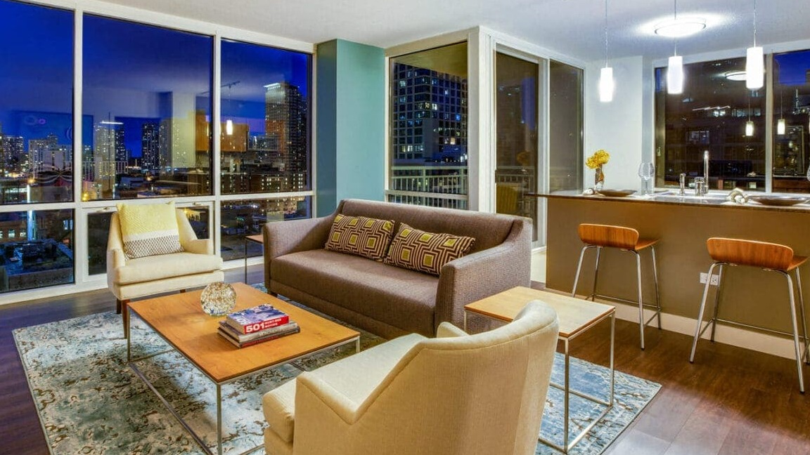 Elegant living room at Flair Tower Apartments in Chicago, boasting floor-to-ceiling windows with stunning nighttime city views