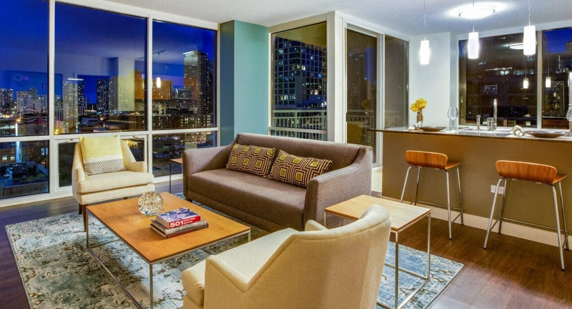 Elegant living room at Flair Tower Apartments in Chicago, boasting floor-to-ceiling windows with stunning nighttime city views