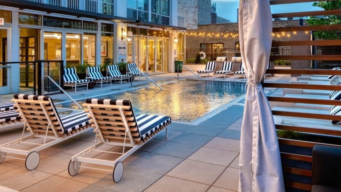 Serene poolside lounge area at Flair Tower Apartments in Chicago, with comfortable loungers, cabanas, and a relaxing ambiance