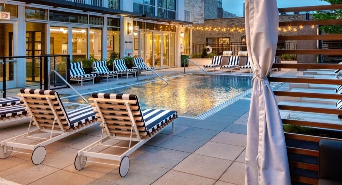 Serene poolside lounge area at Flair Tower Apartments in Chicago, with comfortable loungers, cabanas, and a relaxing ambiance