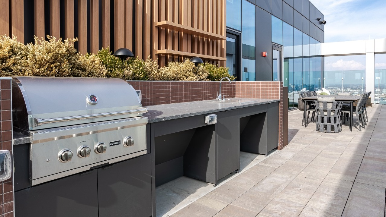 Modern rooftop grilling station at Flora apartments in Chicago, equipped with a large grill and ample counter space for outdoor cooking and entertaining