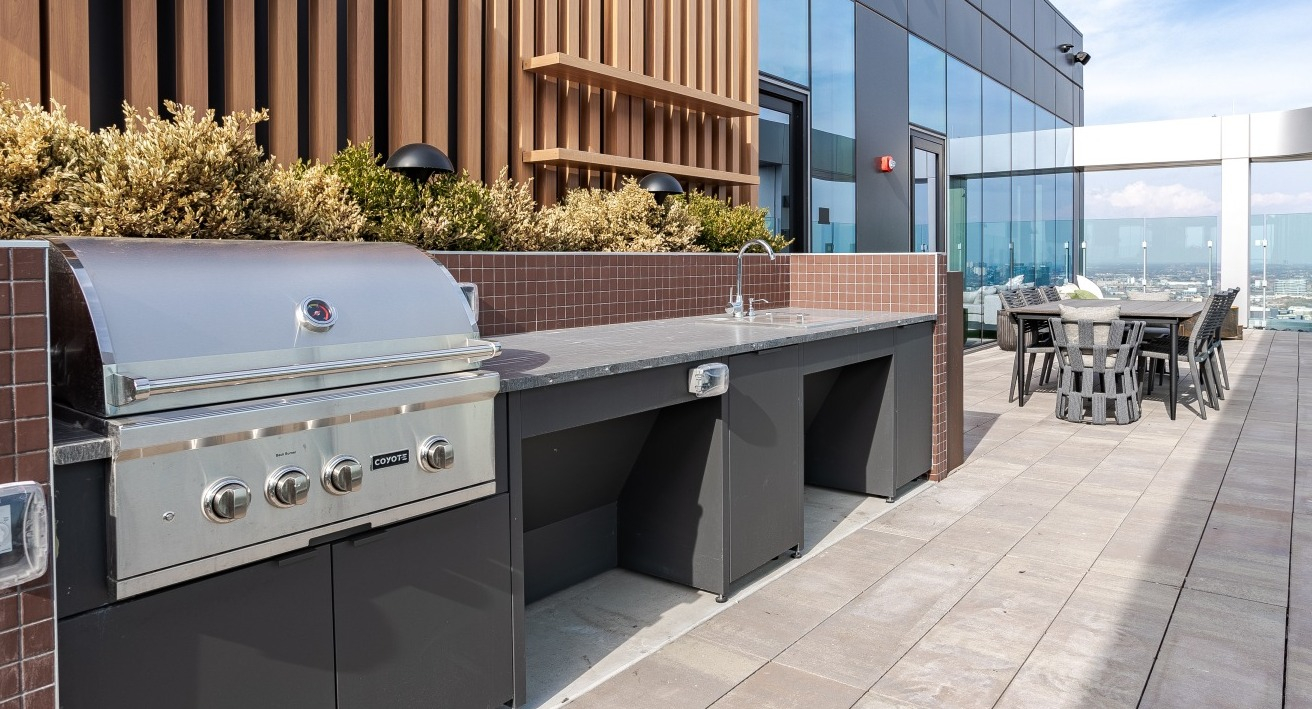 Modern rooftop grilling station at Flora apartments in Chicago, equipped with a large grill and ample counter space for outdoor cooking and entertaining