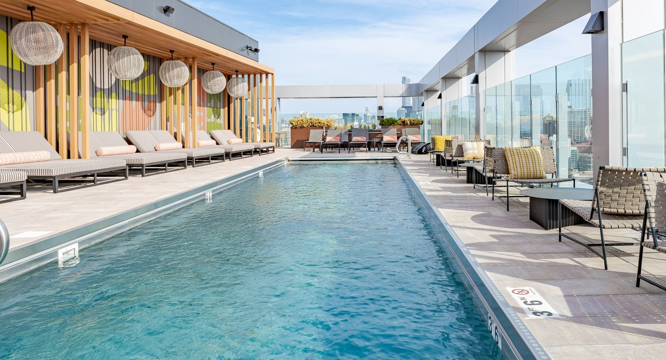 Expansive rooftop pool at Flora apartments in Chicago, offering breathtaking city views, comfortable seating, and a vibrant outdoor atmosphere