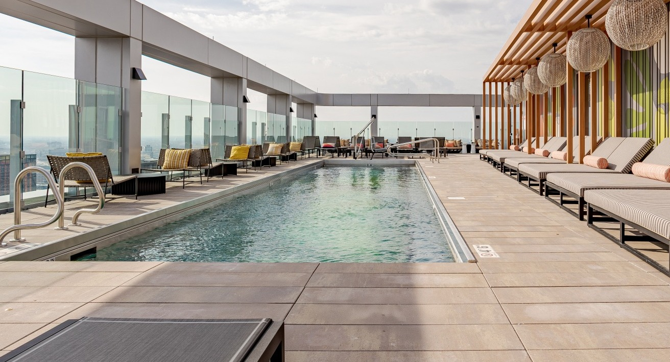 Serene rooftop pool at Flora apartments in Chicago, surrounded by comfortable loungers, cabanas, and modern design for ultimate relaxation