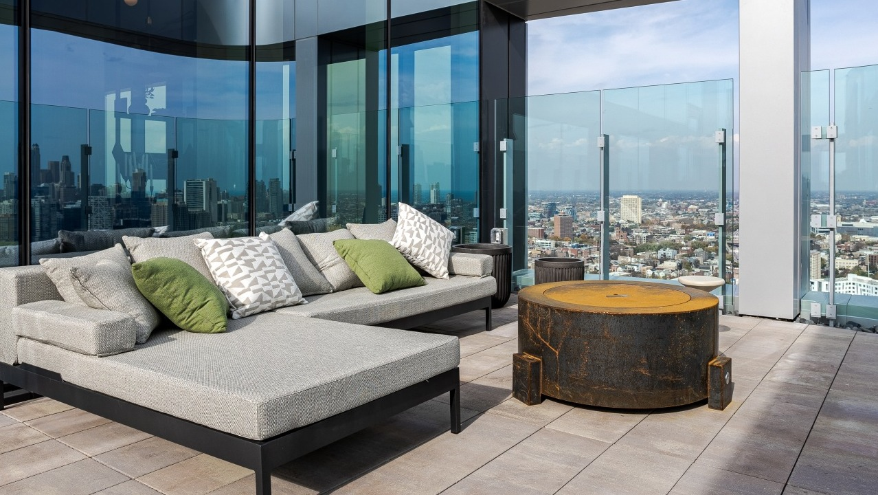 Luxurious rooftop terrace at Flora apartments in Chicago, featuring comfortable lounge seating, a modern fire pit, and panoramic city views