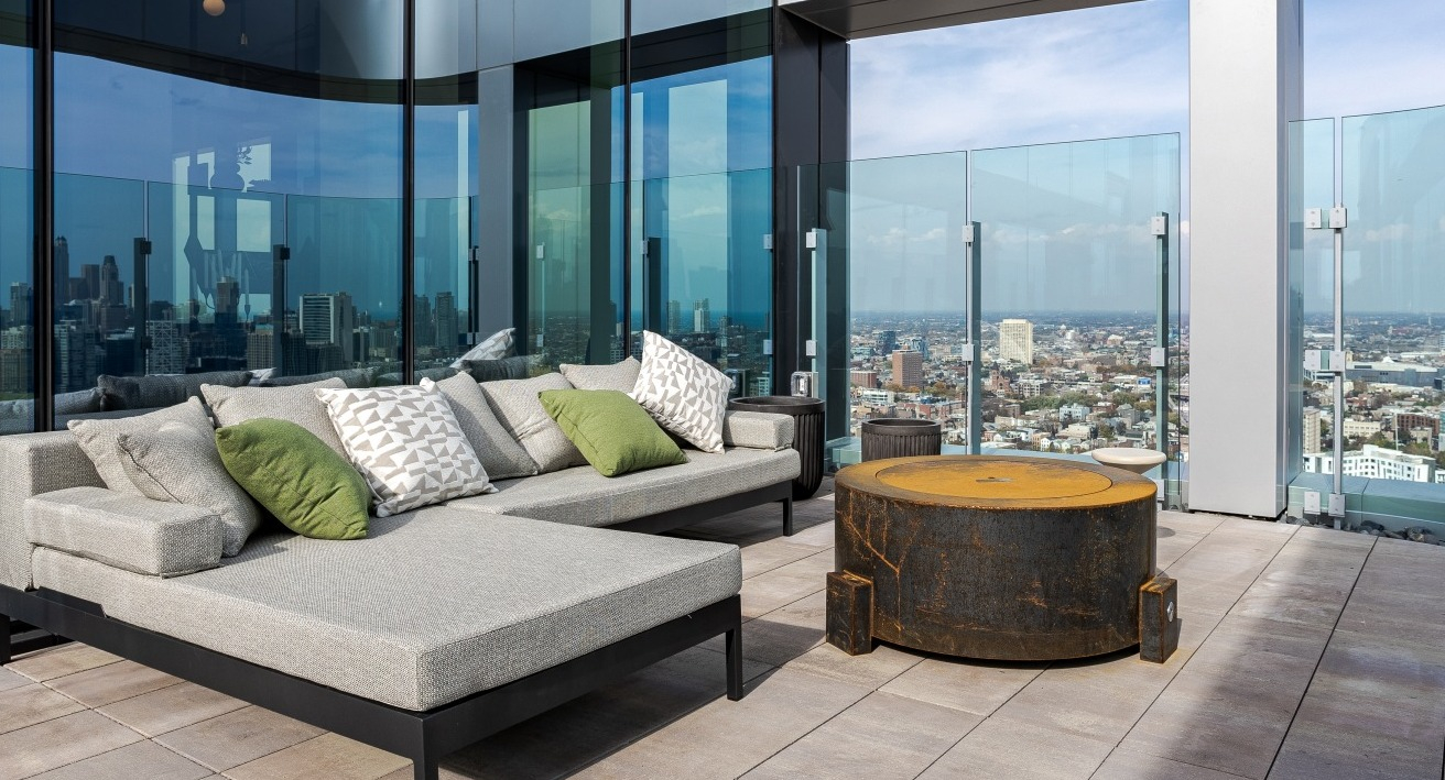 Luxurious rooftop terrace at Flora apartments in Chicago, featuring comfortable lounge seating, a modern fire pit, and panoramic city views