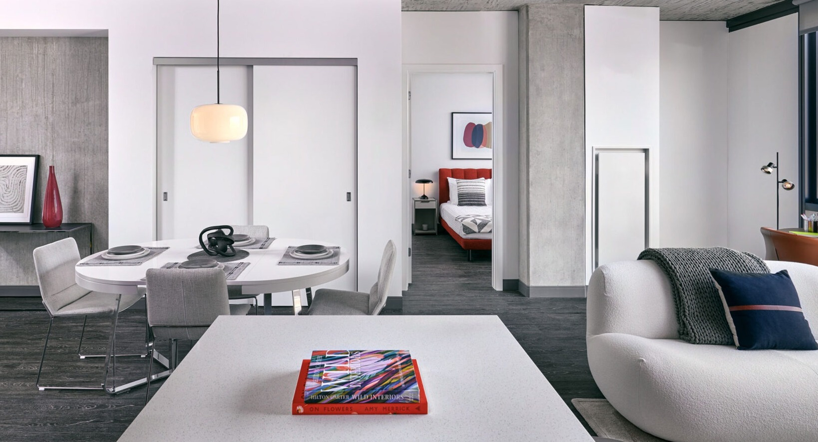 Contemporary apartment interior at Fulbrix Apartments in Chicago, showcasing an open layout from the dining area to a bright bedroom