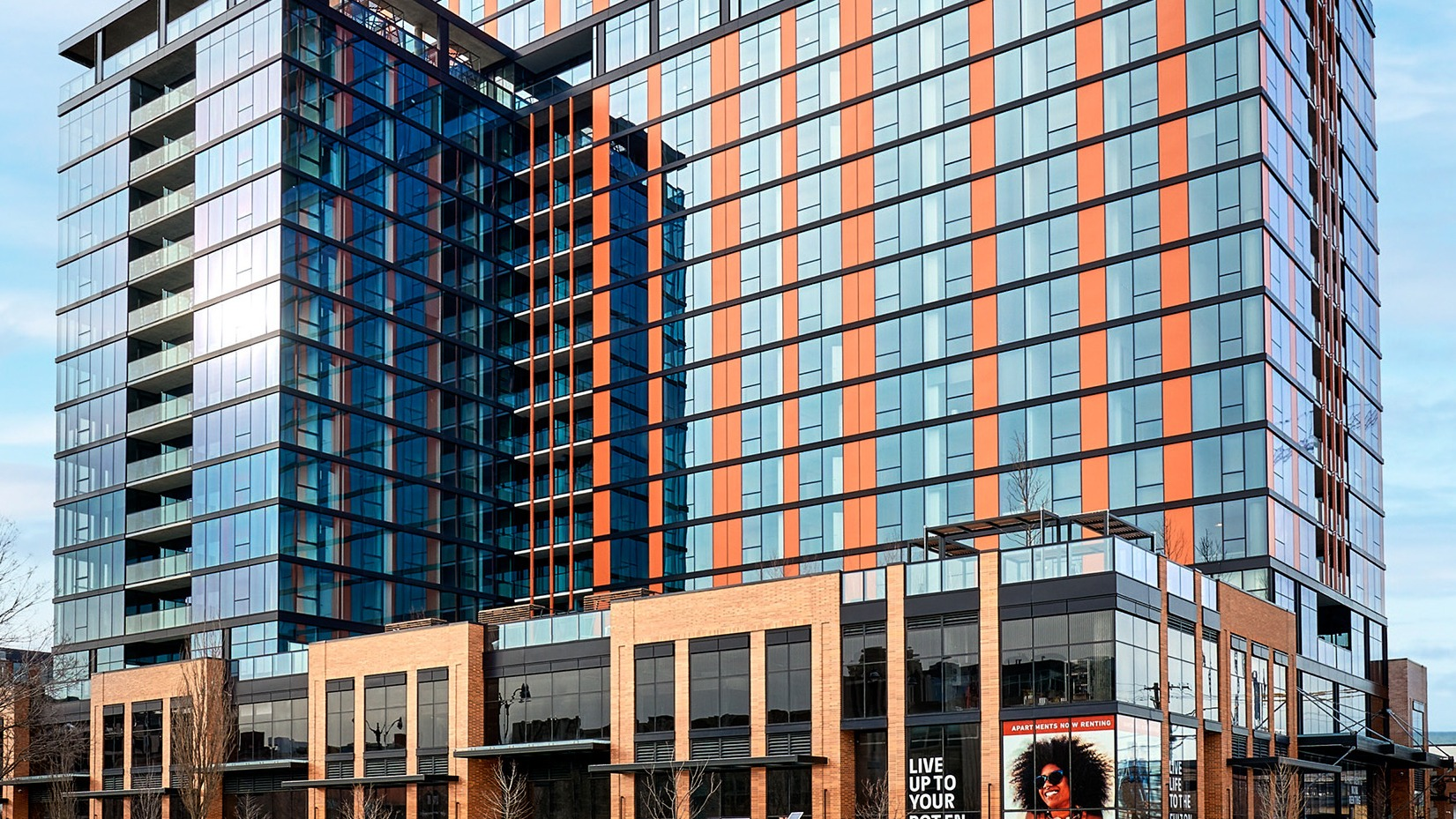 Grand exterior facade of Fulbrix Apartments in Chicago, showcasing modern architecture with orange and blue accents and large windows