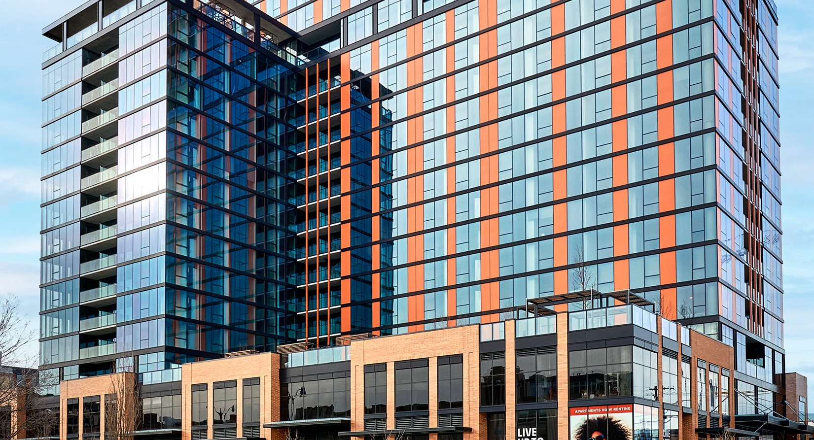 Grand exterior facade of Fulbrix Apartments in Chicago, showcasing modern architecture with orange and blue accents and large windows